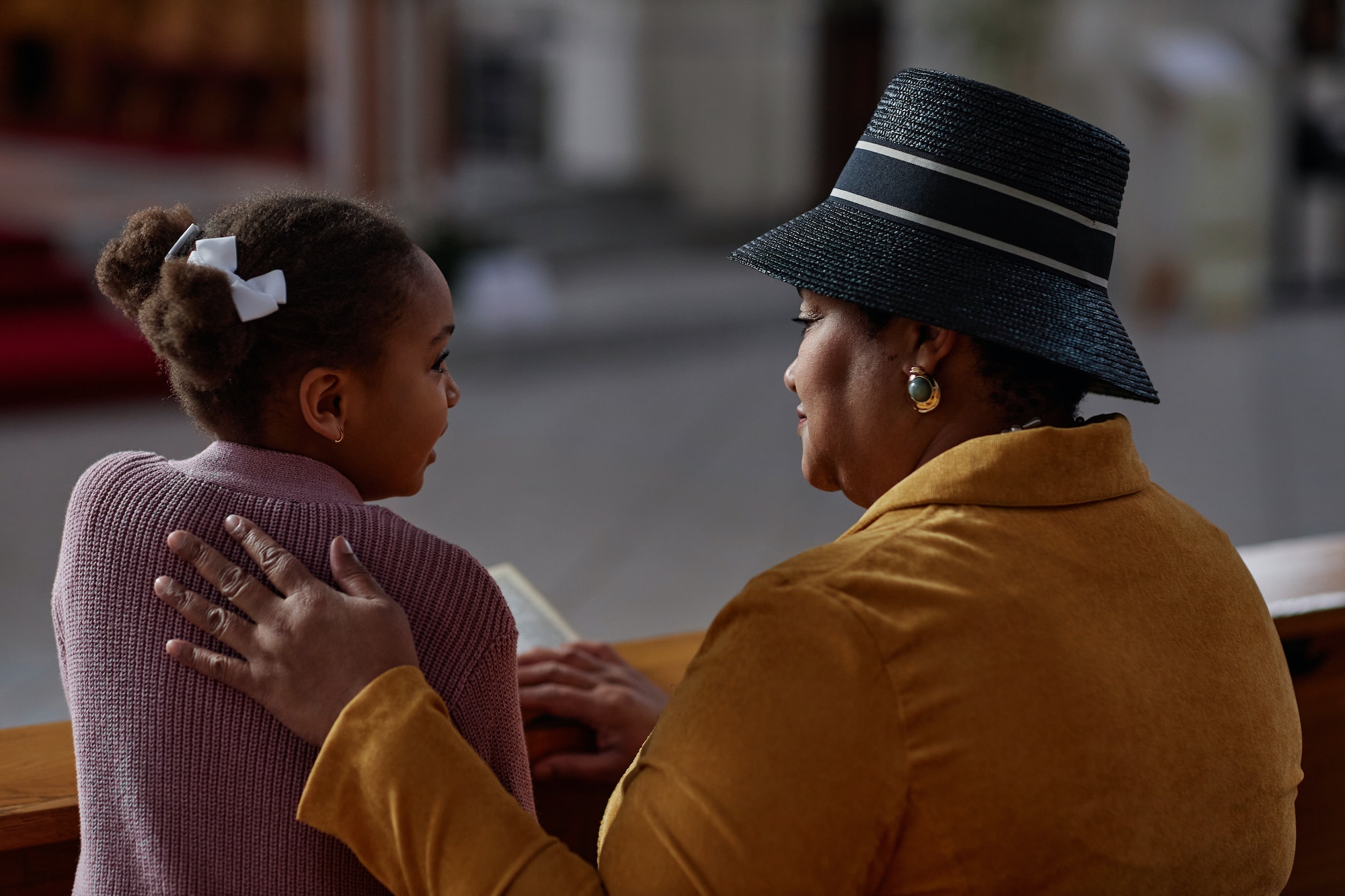 Grandmother reading prayer together with her granddaughter