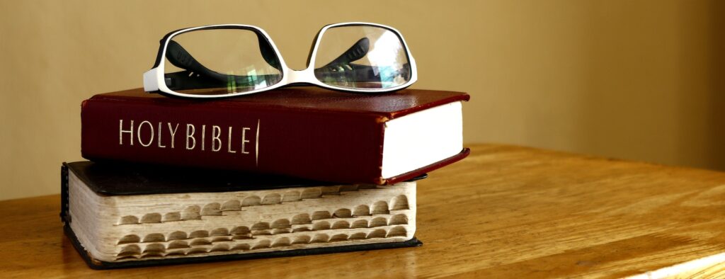 Holy Bibles and eyeglasses on a table